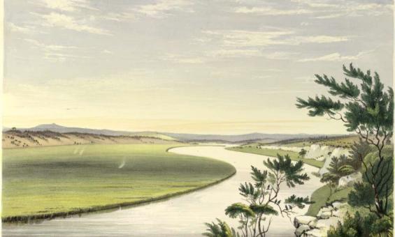 A calm river snakes into the distance, with green grass on one side and trees on the other