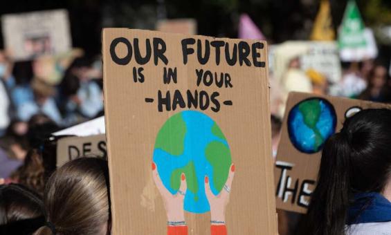 Protester holding a placard that reads, Our Future is in Your Hands