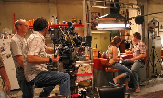 Two actors and a small film crew in a kitchen