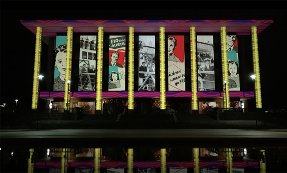 The National Library of Australia building at dusk, lit up with colourful projections.