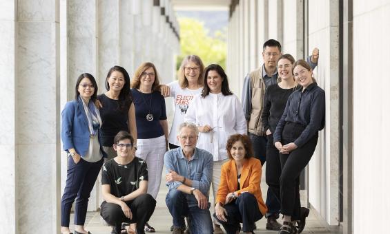 Eleven people posed for a photo under the National Library's exterior colonnade.