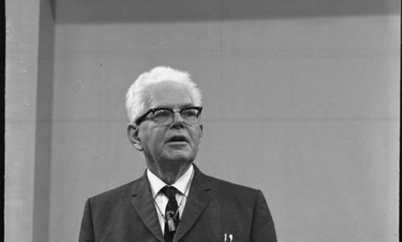 black and white photograph of a man lecturing at a lecturn