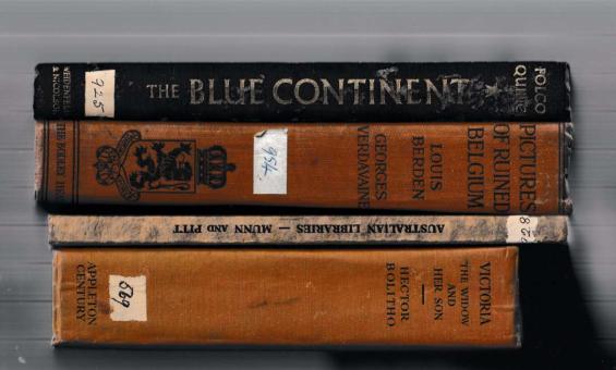 A stack of old books with brown and black spines