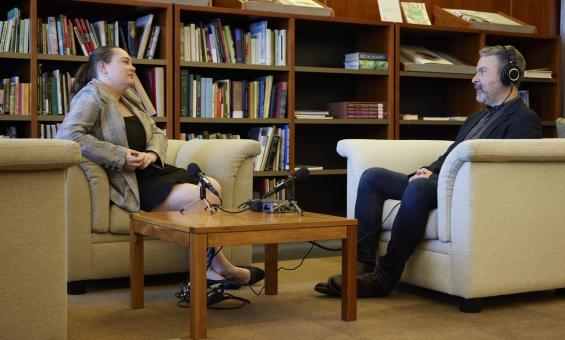 A man and woman sitting on couches recording an oral history interview