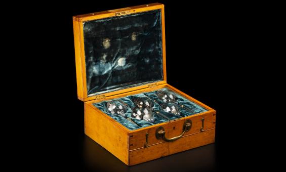 Glass x-ray bulbs/tubes laid on teal velvet in a wooden box