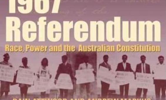 A sepia-toned book cover with a faint handwritten text background features a historic image of people holding protest signs.