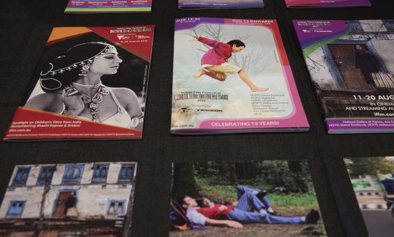 Brochures from various years of the Indian Film Festival of Melbourne on a black surface