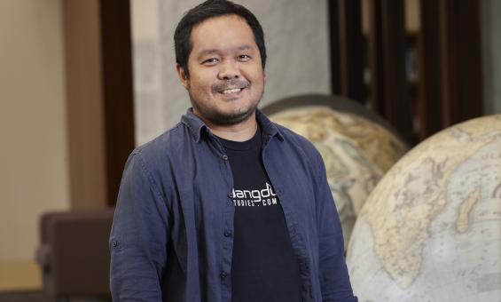 Michael Raditya standing in the Main Reading Room and smiling