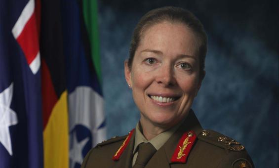 A smiling woman dressed in military clothing