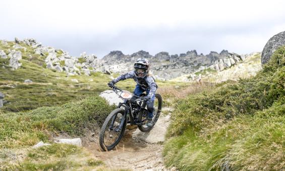 Mountain biker in full gear riding a rocky, dirt path