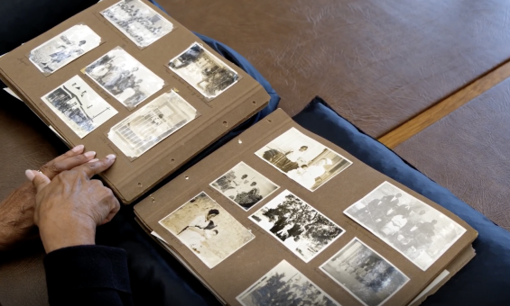 Wirangu Elder, Sandra Miller looking at a photo album and pointing at a piicture of a relative