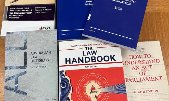 Six books about Australian legislation spread on a wooden table